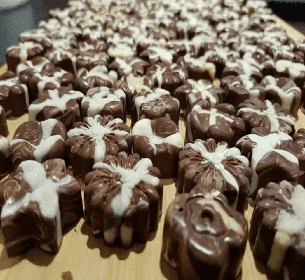 A collection of homemade milk chocolates with white chocolate decorations.