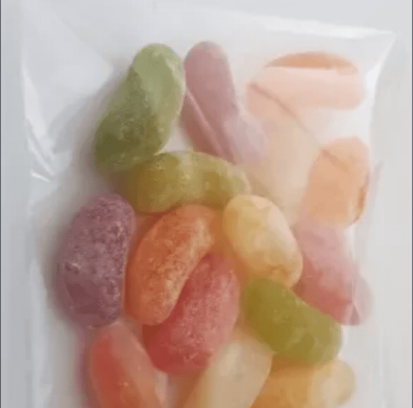 A close-up of a sealed clear plastic bag containing assorted colorful jelly beans.